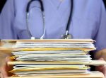 nurse or doctor holding a stack of files in folders