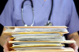 nurse or doctor holding a stack of files in folders